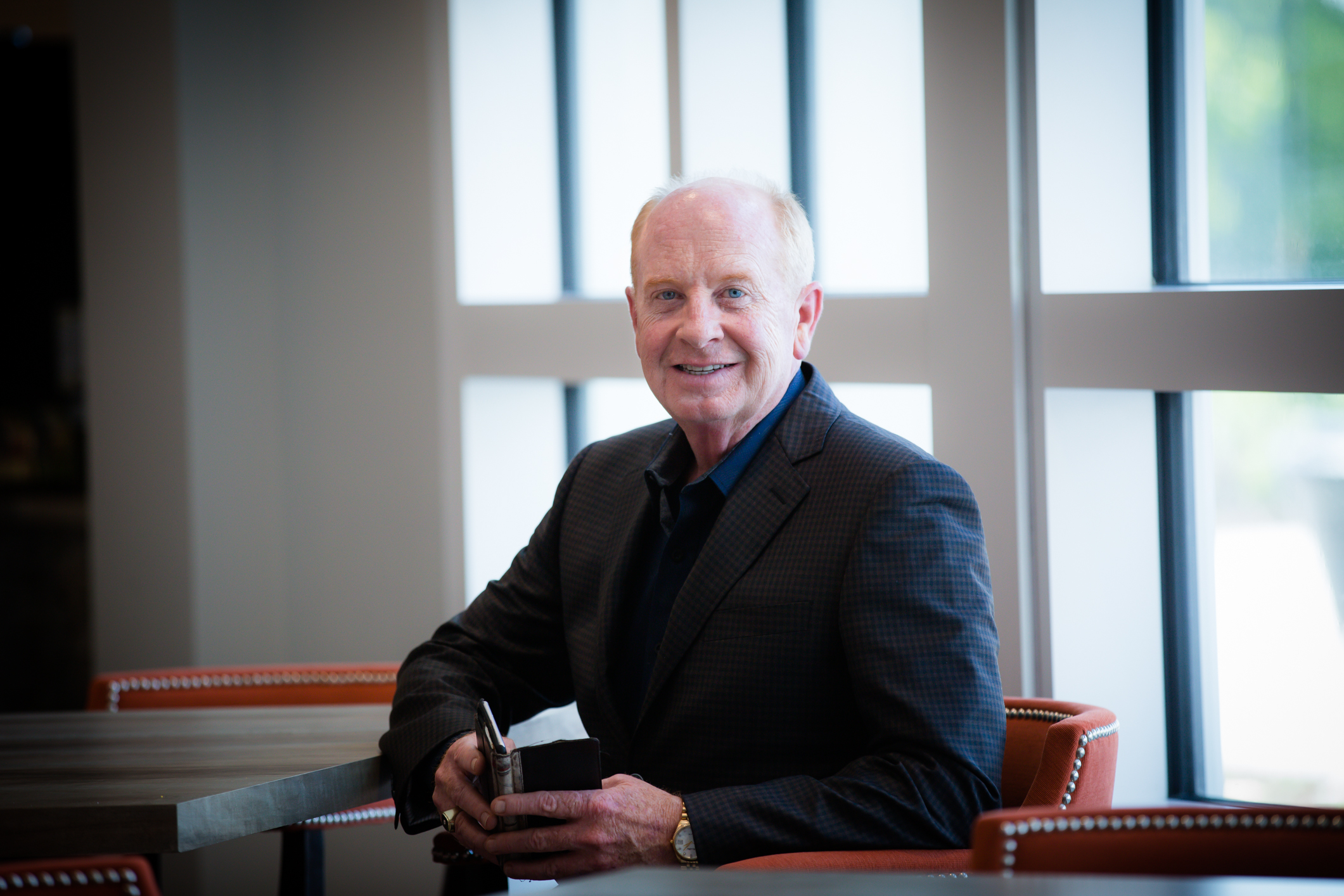 Executive portrait of Steve Shields, CEO of Norterre, seated at table with large windows, Kansas City