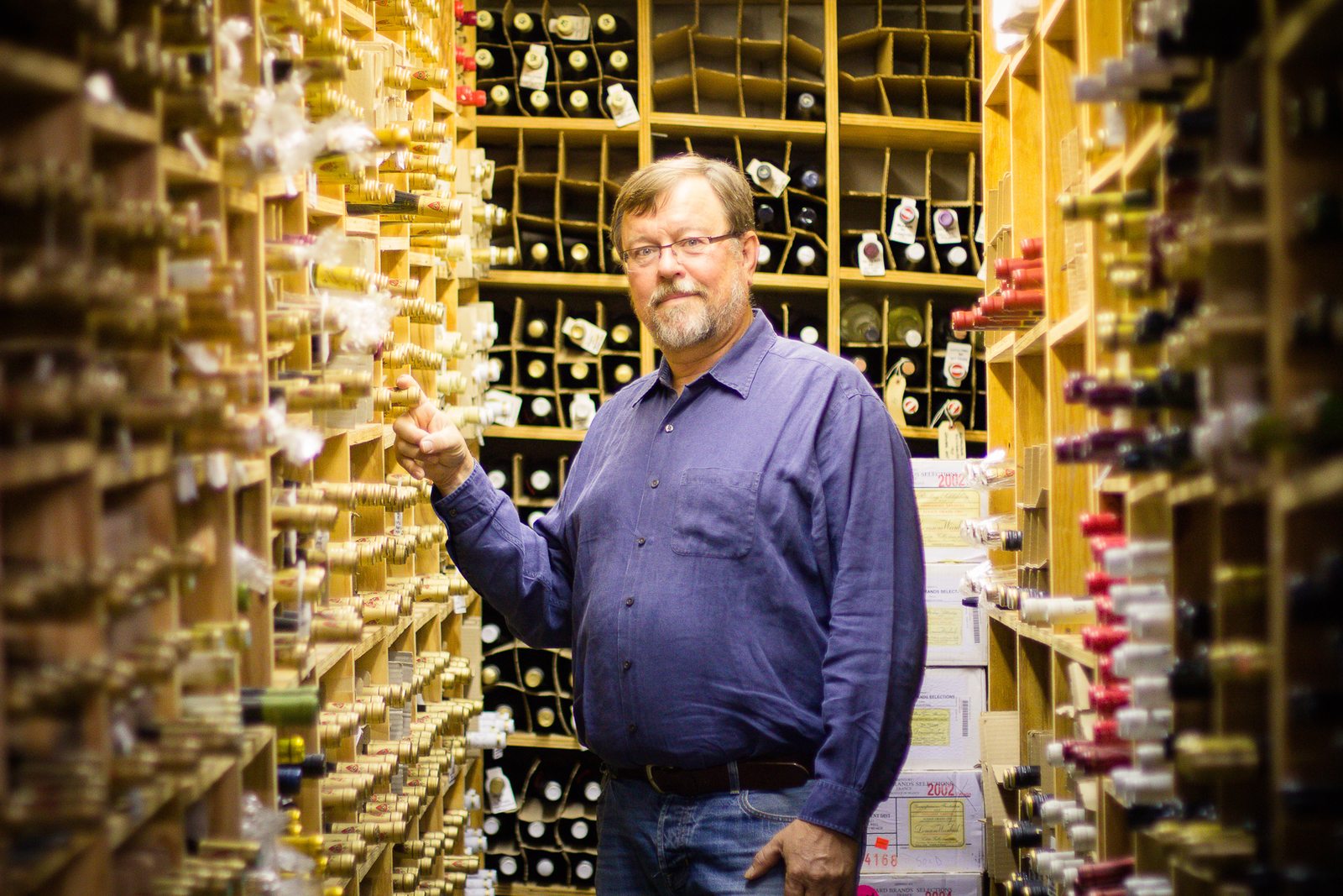 Eisterhold Associates team member standing beside wine bottles in the winery that housed the exhibit design firm.